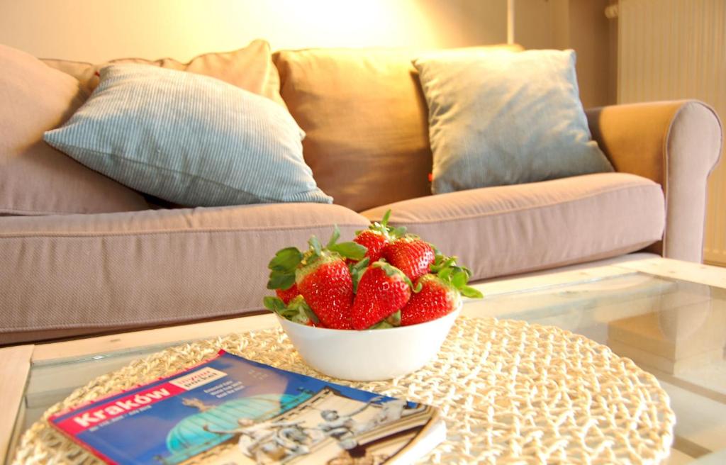 eine Schale Erdbeeren auf einem Couchtisch im Wohnzimmer in der Unterkunft Friedleina 7 Kamienica Prezydencka in Krakau
