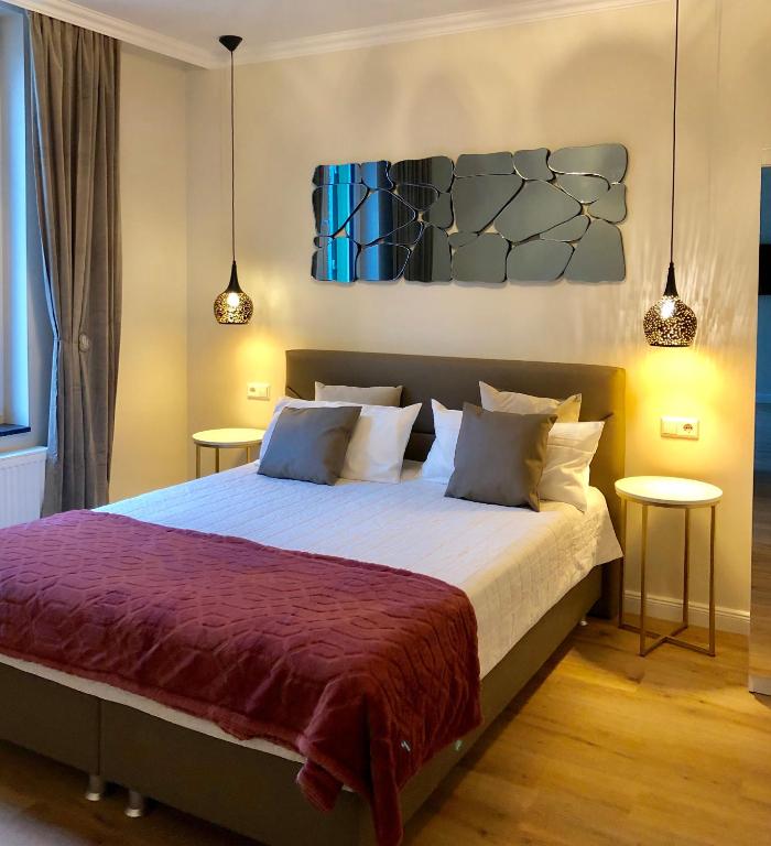 ein Schlafzimmer mit einem großen Bett mit zwei Tischen in der Unterkunft Reichel-Appartements in Baden-Baden