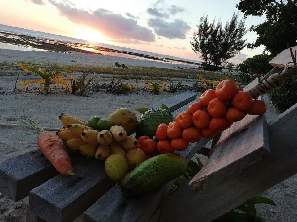 塔纳岛奥法海滩简易别墅的坐在海滩长凳上的一大堆水果和蔬菜