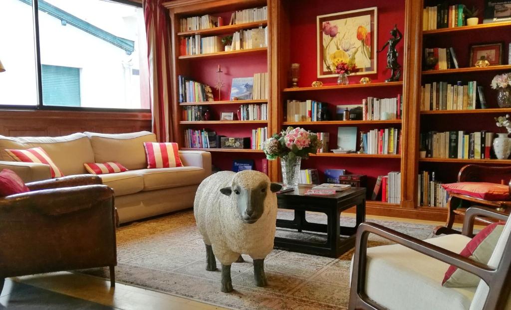uma sala de estar com uma estátua de uma ovelha numa sala de estar em Hôtel La Marisa Grande Plage em Saint-Jean-de-Luz