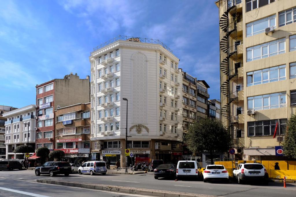 イスタンブールにあるHOTELOZBEKの車の通り沿いの高い白い建物