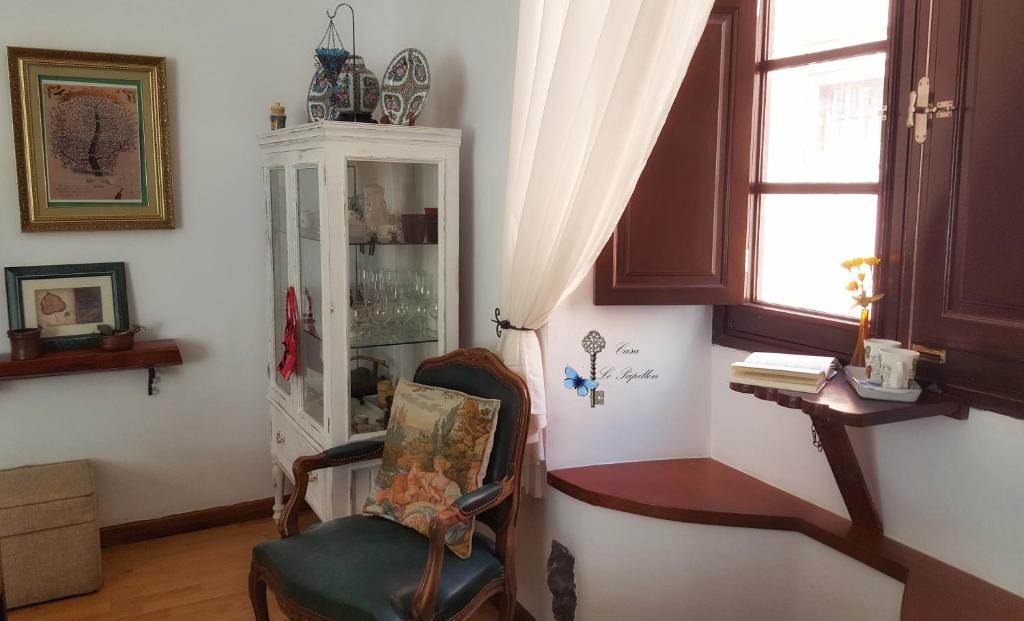 una habitación con una silla y un armario de porcelana en Casa Le Papillon en La Laguna