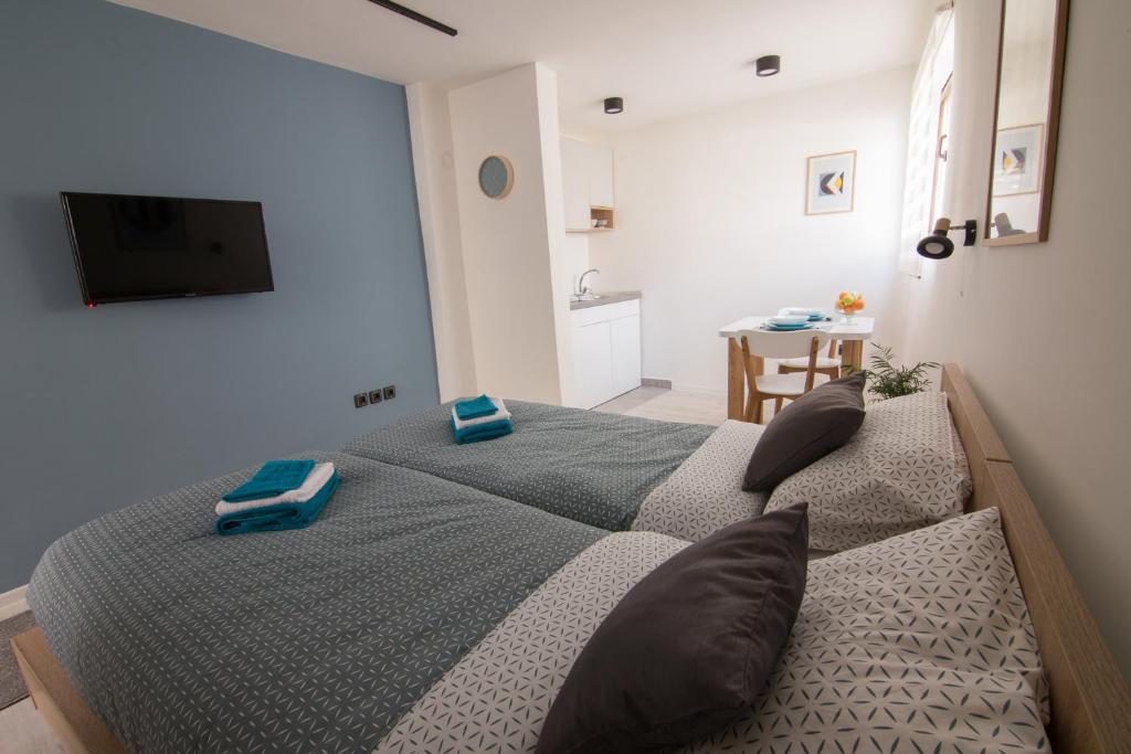 a bedroom with a bed with blue towels on it at Sunrise Apartments in Niš