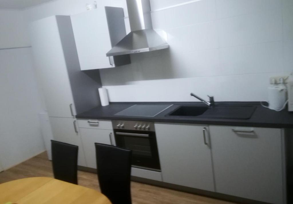 a kitchen with a sink and a stove at Ferienwohnungen Untermühle, Rothenbergerstr. 12 in Altenau