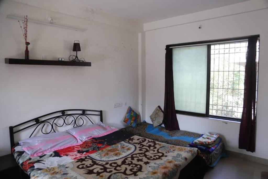 - une chambre avec un lit et une fenêtre dans l'établissement Joey's villa, à Lonavala