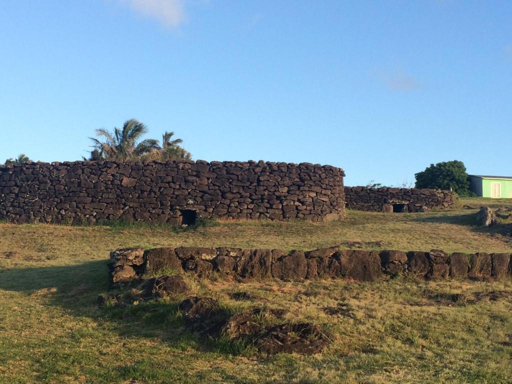 a stone wall in the middle of a field at Inaki Uhi Hotel in Hanga Roa