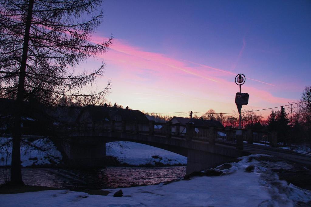 a bridge over a river with a sunset in the background at Žamberk-apartmán líšnice in Žamberk