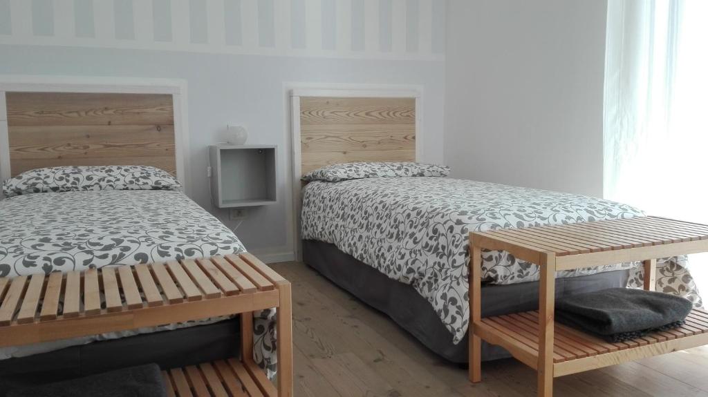 アルコにあるAppartamento caneveのベッドルーム1室(ベッド2台、木製ベンチ付)