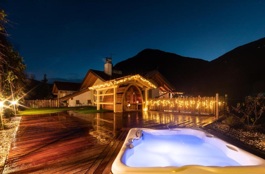 a hot tub on a wooden deck with lights at Hotel Appartement Haus Gitschberg in Vandoies