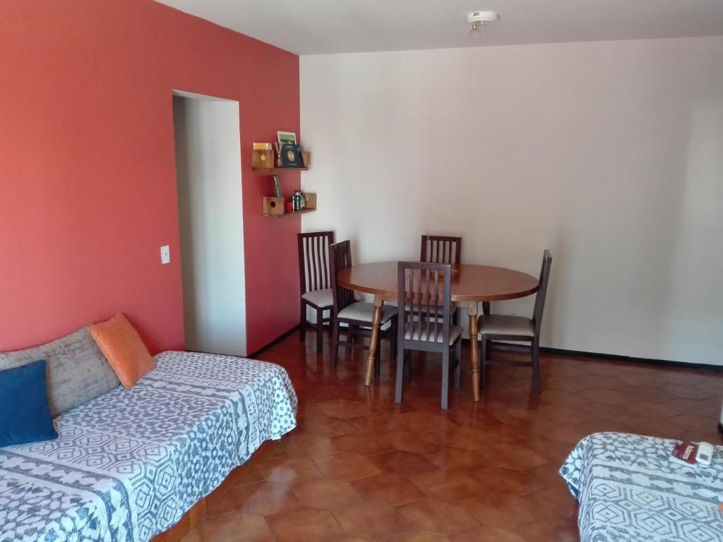 Una sala de estar con un sofá, una mesa y sillas. en Colon Apartment, en Mendoza