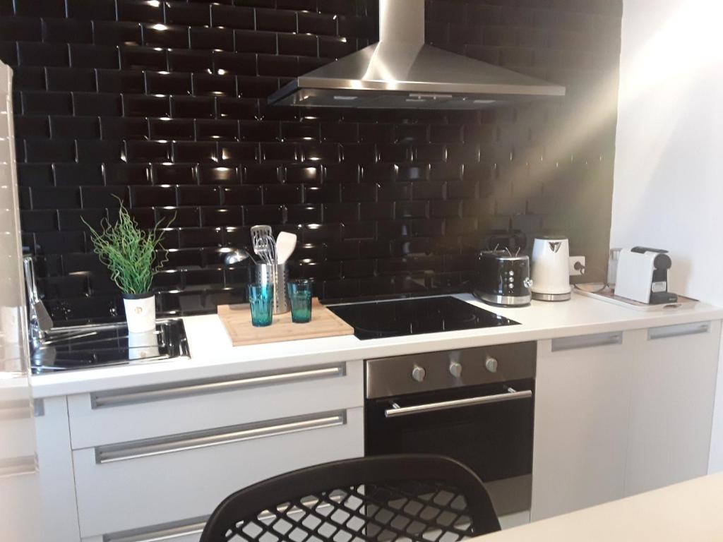 a kitchen with a stove and a black wall at Hébergement Les Heros in Liège