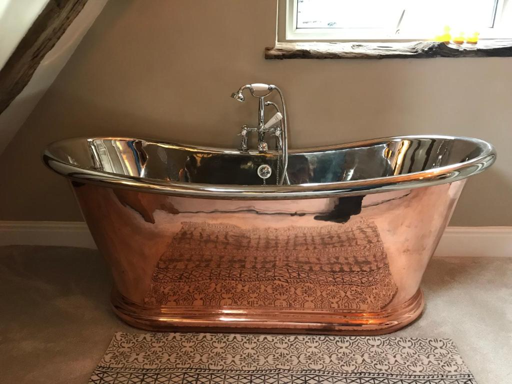 a bath tub sitting in a bathroom next to a window at Galtres Lodge Hotel & Forest Restaurant in York