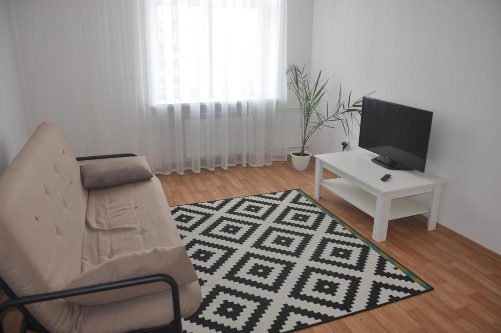 een woonkamer met een bank, een tv en een tafel bij Apartments Theatre Shepkina 2 room in Sumy