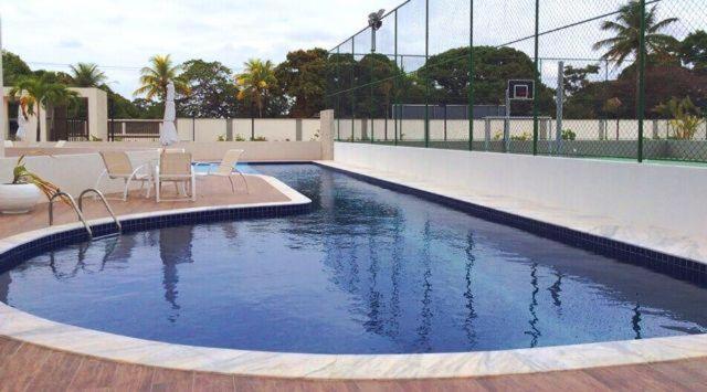 a swimming pool with chairs and a basketball court at Apt alto padrão todo mobiliado e decorado em cond. Fechado in Maceió