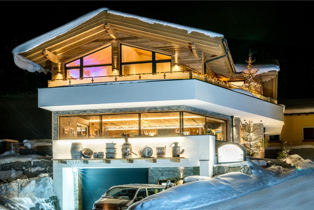 une maison avec une voiture garée devant elle dans l'établissement Stockis Mountaindestillerie - Appartements, à Leogang