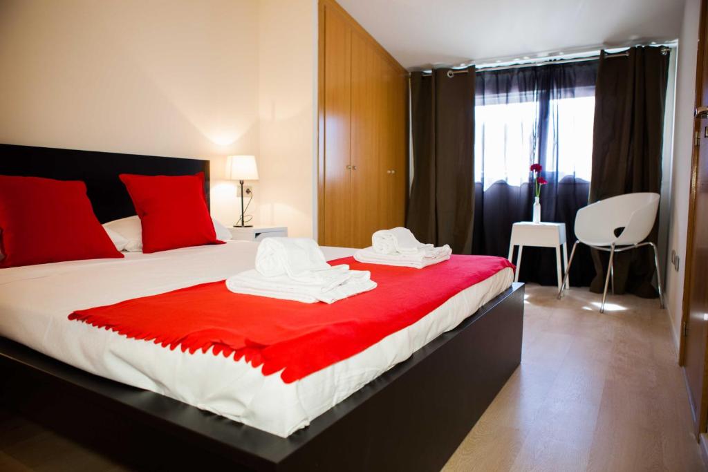 a bedroom with a large bed with red and white sheets at Hulot B&B Valencia in Valencia