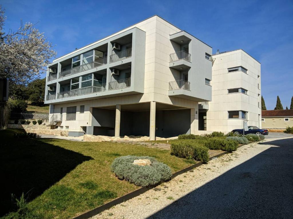 un gran edificio blanco con un patio delante en Romana Dream apartment, en Vrsar