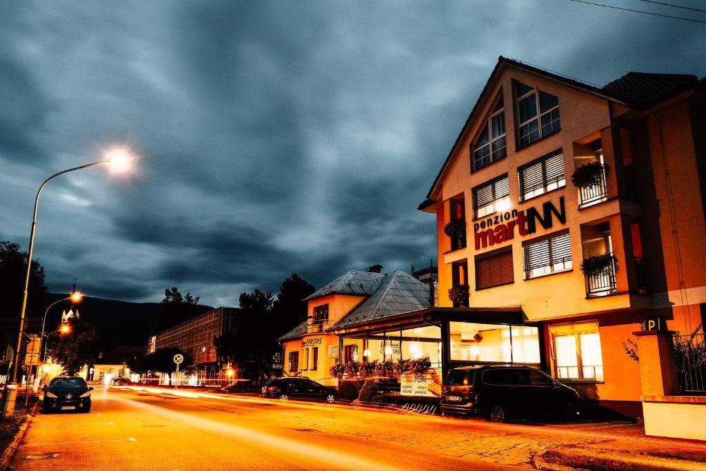 a building on the side of a street at night at Penzion MartInn in Martin