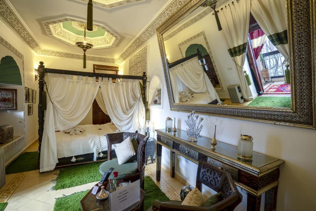1 dormitorio con cama y espejo grande en Riad Anabel, en Marrakech