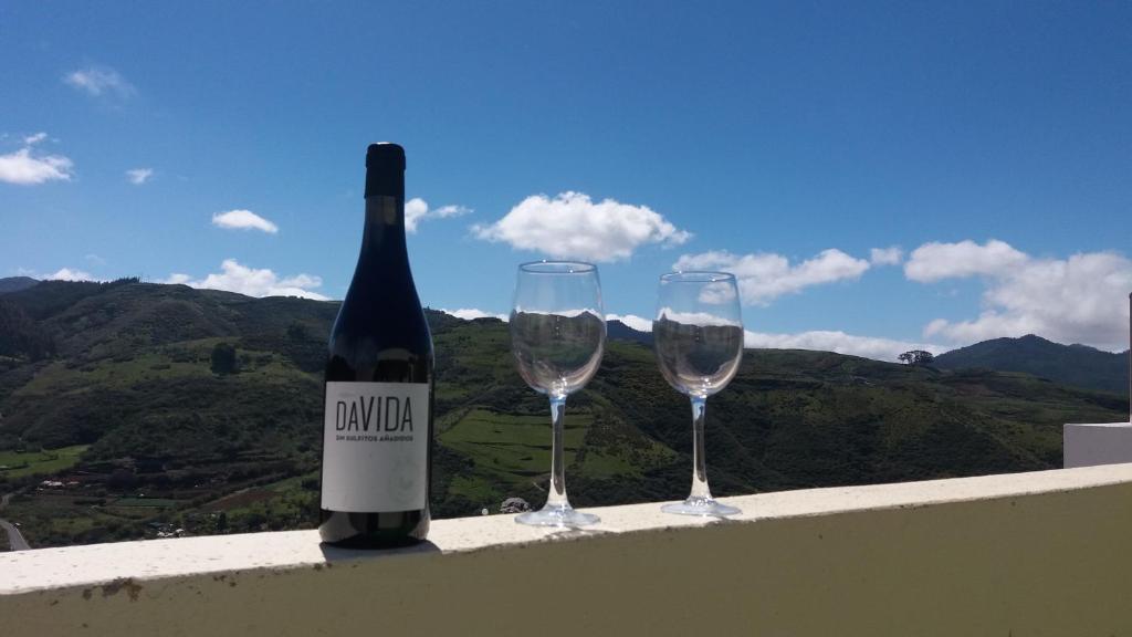 a bottle of wine and two glasses on a ledge at Casa Rural Zalemy in San Pedro
