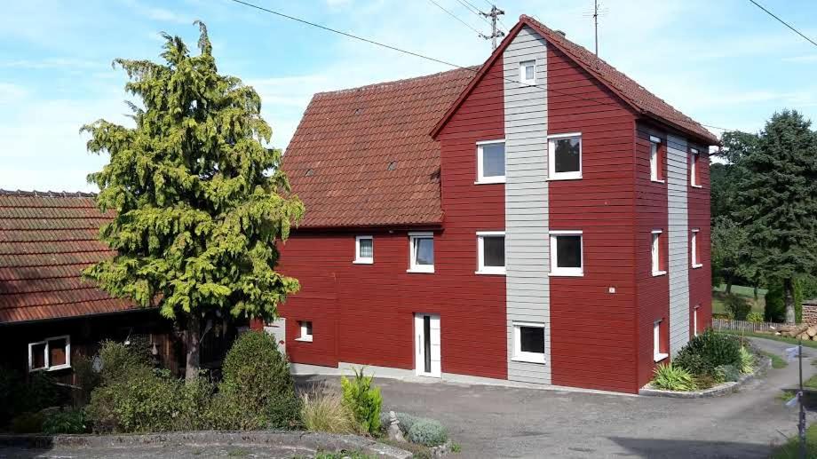 eine große rote Scheune mit rotem Dach in der Unterkunft Gästehaus Bruch in Kaisersbach