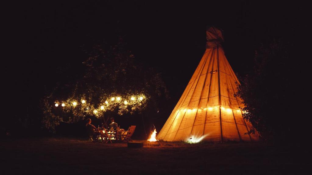 namiot jest oświetlony w nocy światłami w obiekcie White House on Wye Glamping w mieście Hereford