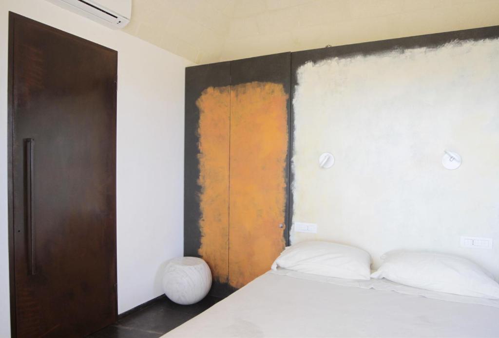 a bedroom with a bed and a wooden headboard at Cala Rossa Lodge in Favignana