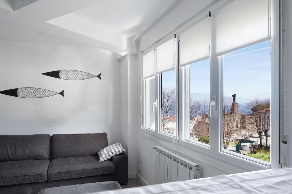 a living room with a couch and a large window at BALENTZIAGA Getaria in Getaria