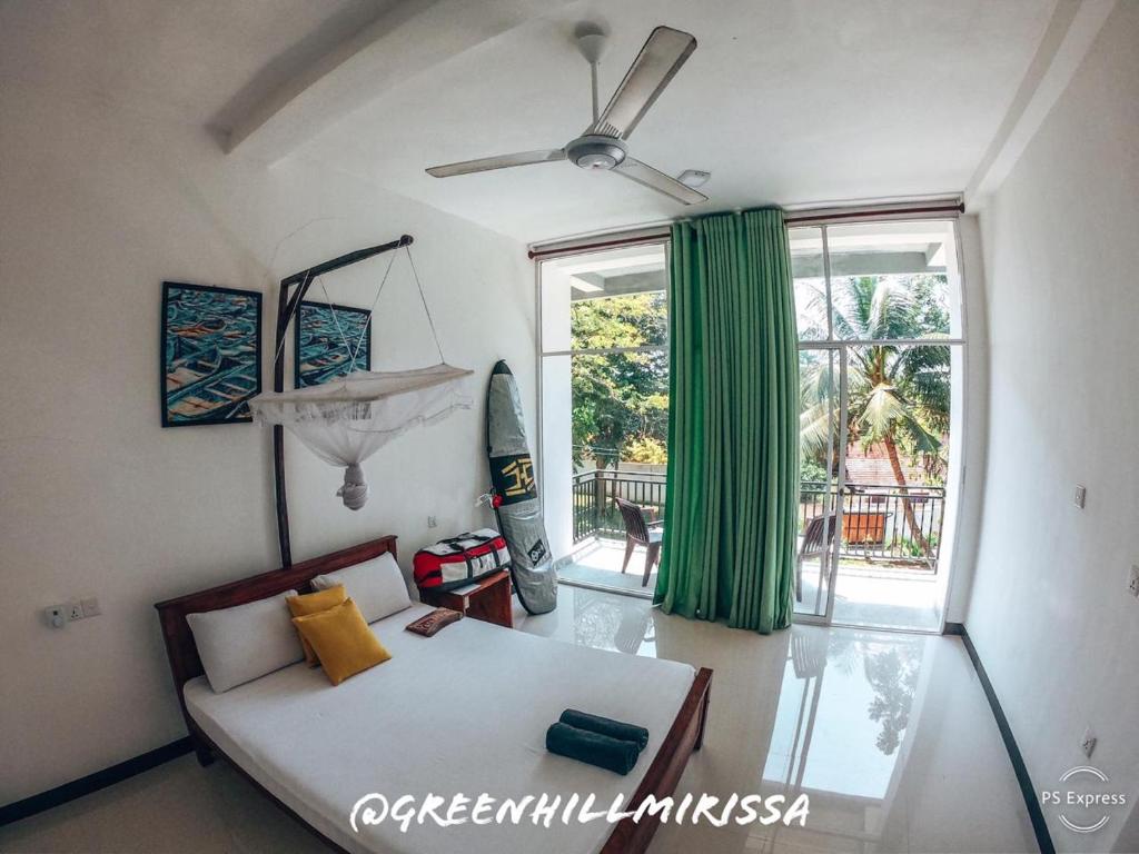 a bedroom with a bed and a large window at Green Hill Mirissa in Mirissa