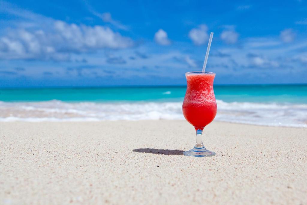 een rood drankje in een glas op het strand bij Siesta Key Dream Vacation in Siesta Key