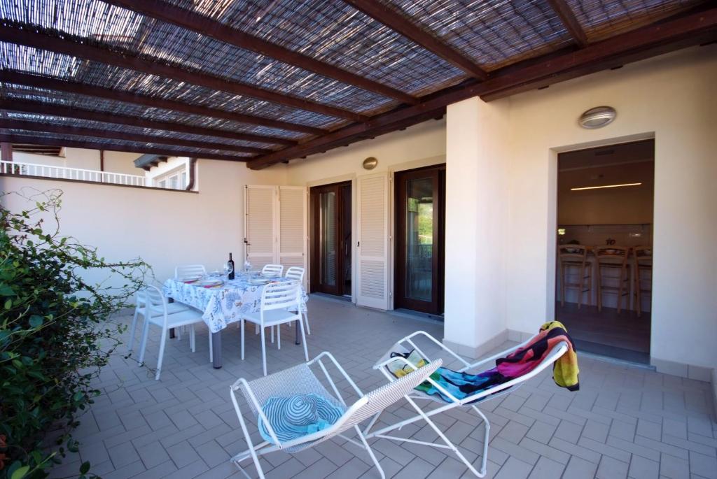 a patio with a table and chairs and a dining room at Appartamenti Procchio in Procchio