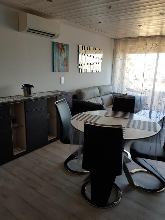 - un salon avec une table et des chaises dans l'établissement Studio Naturiste "AZUR" Héliopolis C 64, au Cap d'Agde