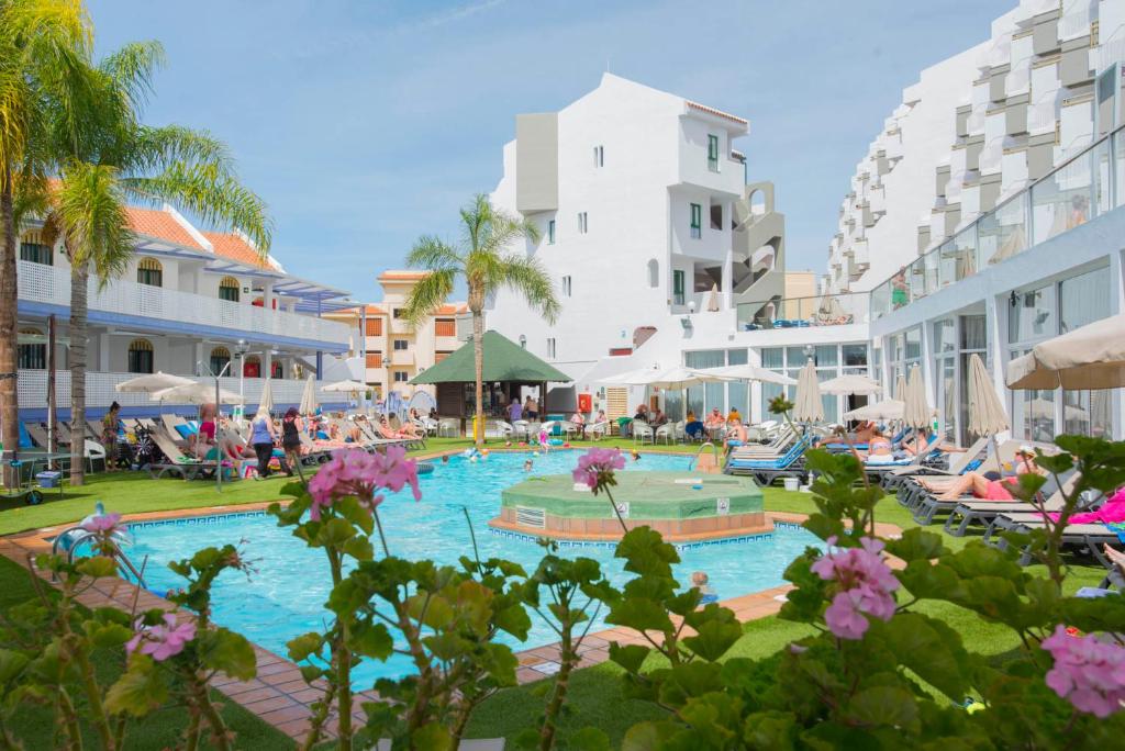 a pool at a resort with people lounging at PlayaOlid All Inclusive in Adeje