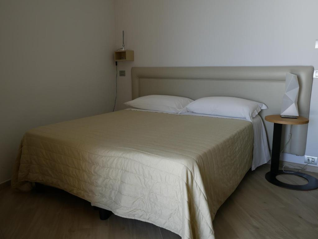 a bedroom with a bed with a lamp on a table at Daedalium in Marina di Palma