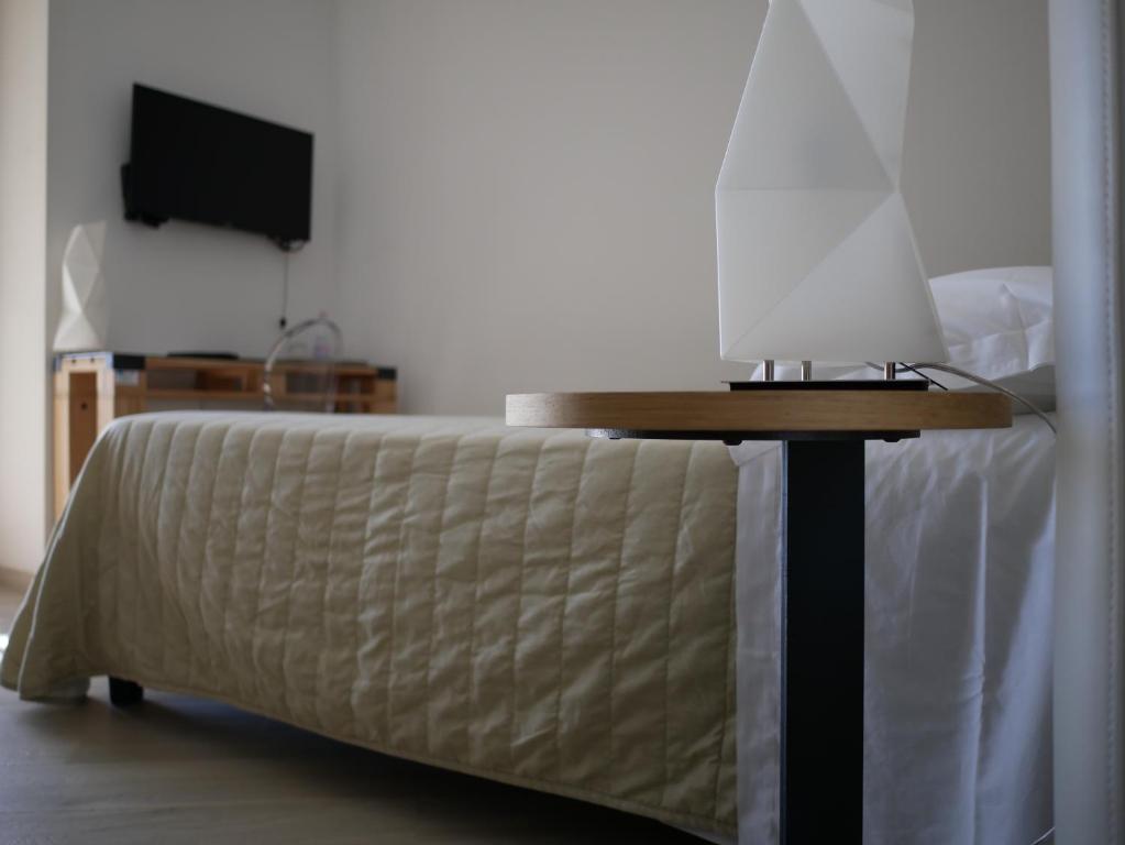 a bedroom with a bed with a table and a tv at Daedalium in Marina di Palma