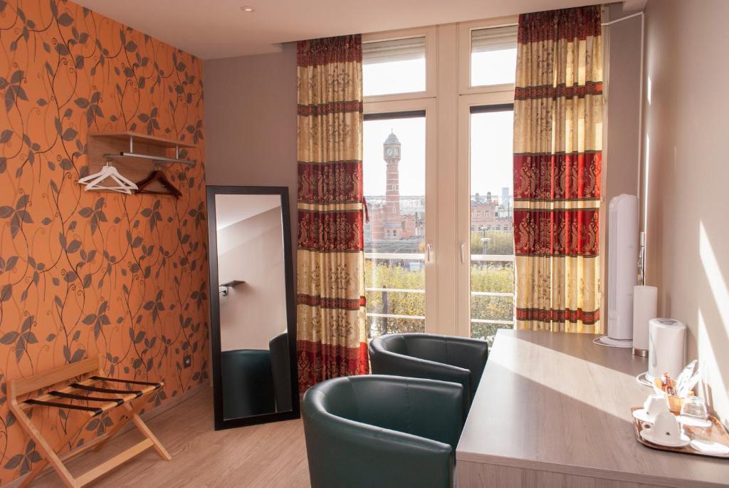 Zimmer mit einem Tisch, Stühlen und einem Fenster in der Unterkunft Hotel Castel in Gent