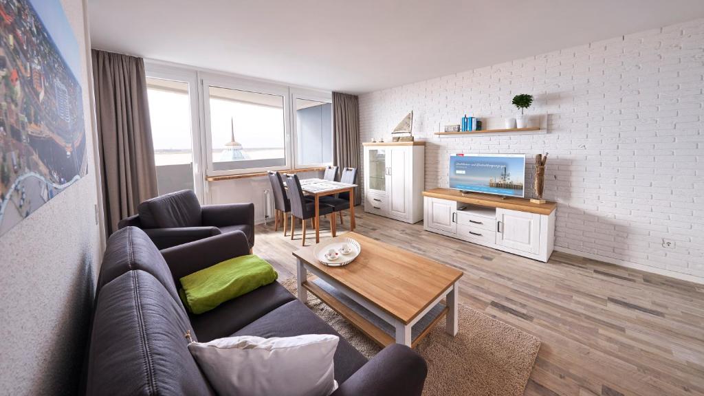 ein Wohnzimmer mit einem Sofa und einem Tisch in der Unterkunft Weserdeichblick in Bremerhaven