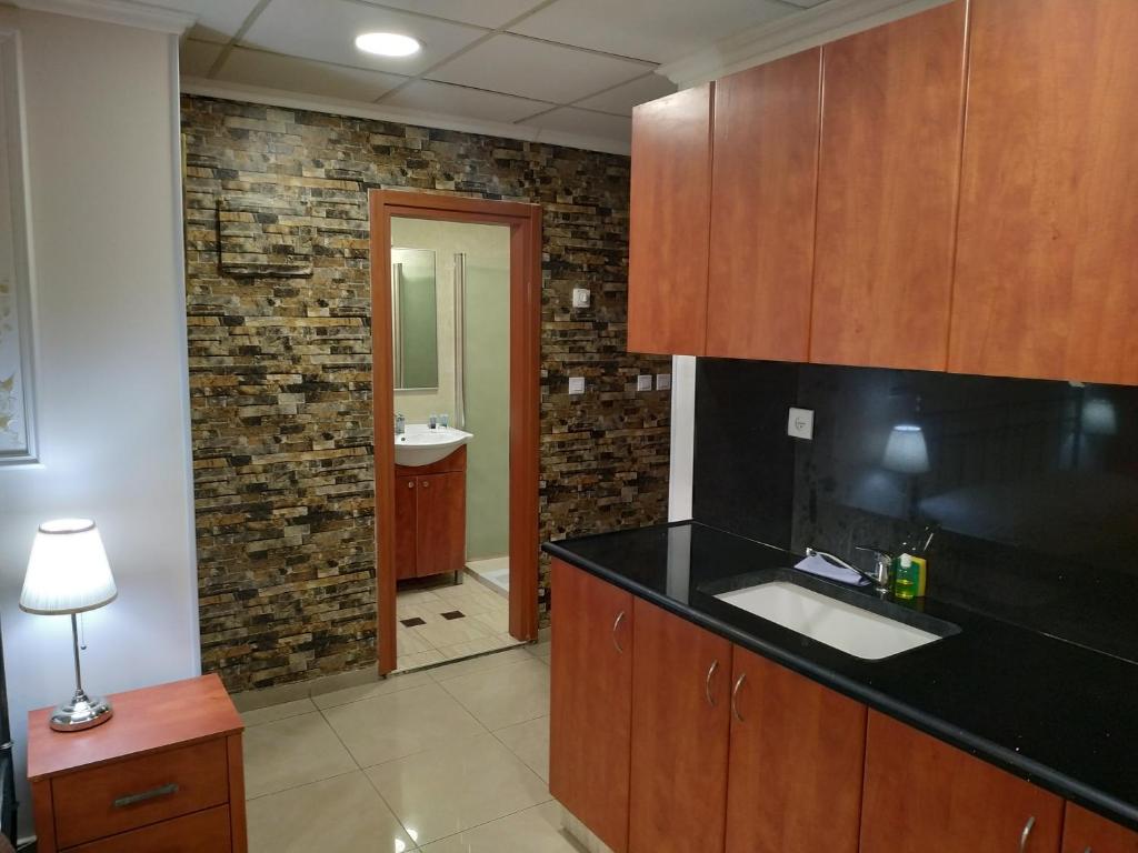 a kitchen with a black counter top and a sink at ApartHotel "Ha-Tzomet" in Bat Yam
