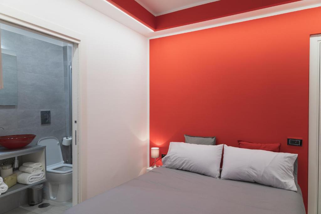 una camera da letto con un letto e una parete rossa di Napoli Capitale a Napoli