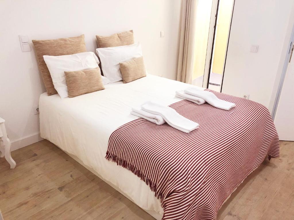 a white bed with two towels on top of it at Lisbon City Studio Apartment in Lisbon