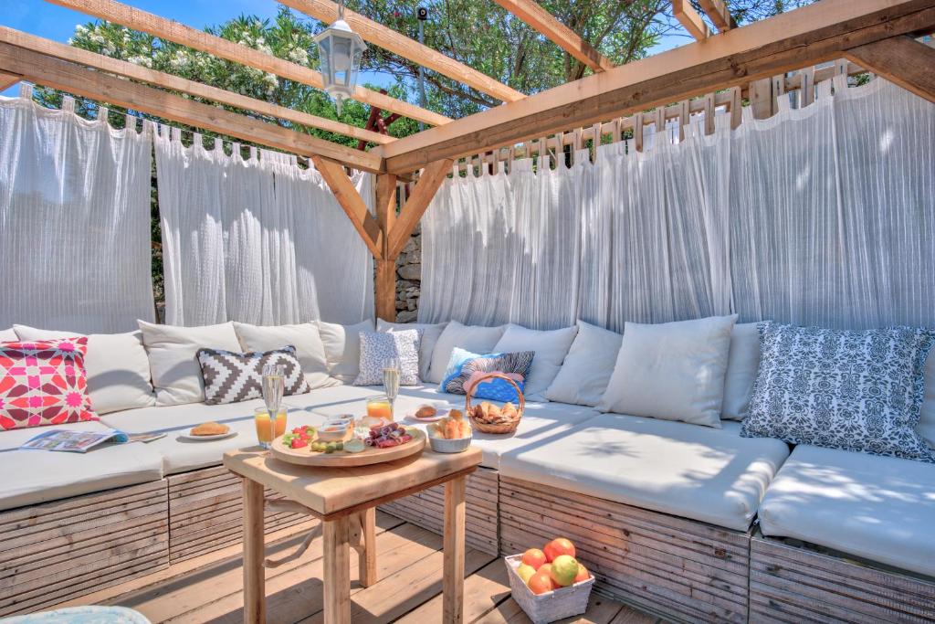 a patio with a couch and a table with food on it at ECO Aparthotel The Dreamers's Club in Lumbarda