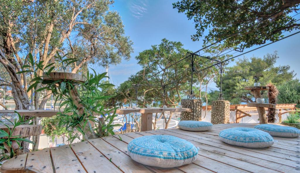 a wooden table with blue pillows on top of it at ECO Aparthotel The Dreamers's Club in Lumbarda
