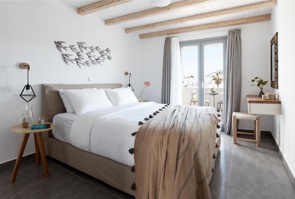 a bedroom with a large bed and a window at Pnoi Luxury Suites in Karterados