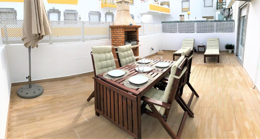 uma sala de jantar com uma mesa e cadeiras e uma lareira em Apartamento Praia de Altura com Terraço, Barbecue, A/C e Wifi em Altura