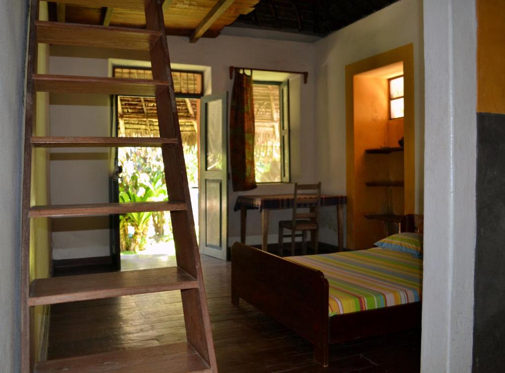 ein Schlafzimmer mit einem Etagenbett und einer Leiter in der Unterkunft Patio dos quintalinhos - Casa di Gabriele in Ilha de Moçambique