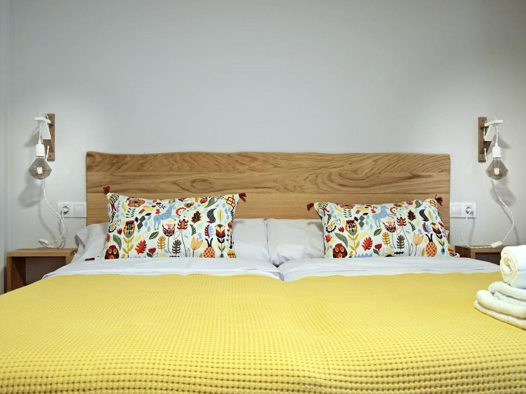- une chambre avec un grand lit jaune et 2 oreillers dans l'établissement Apartamento Estella-Lizarra, à Estella