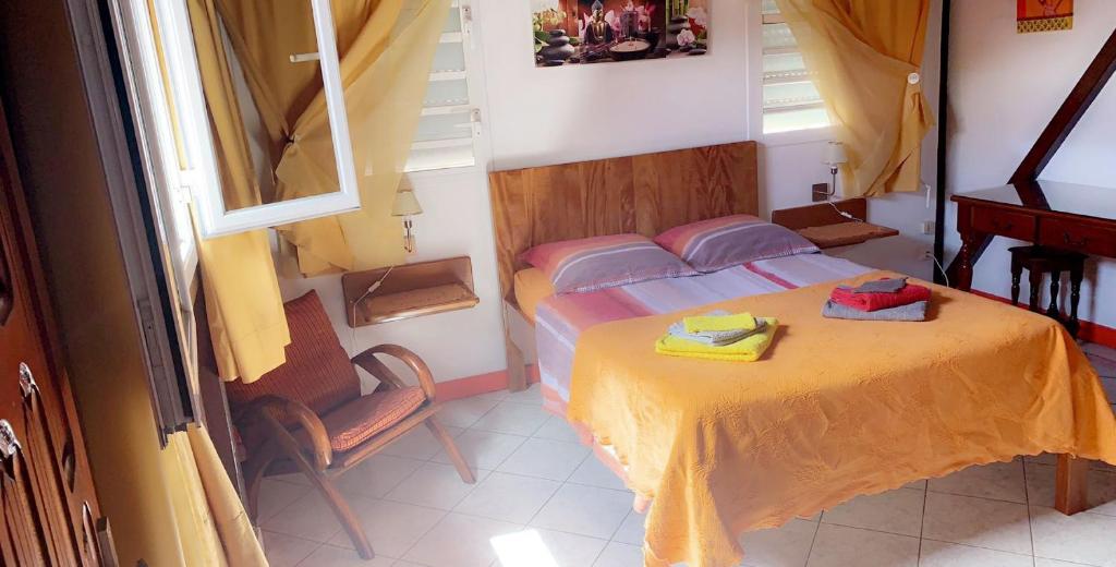 um pequeno quarto com uma cama e uma cadeira em Gites Les Sandragons em Saint-Claude