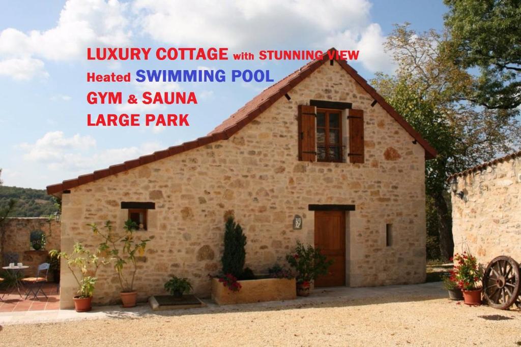 a house in a village with a sign that reads luxury cottage with swimming pool at Hillside Park Dordogne in Saint-Lazare