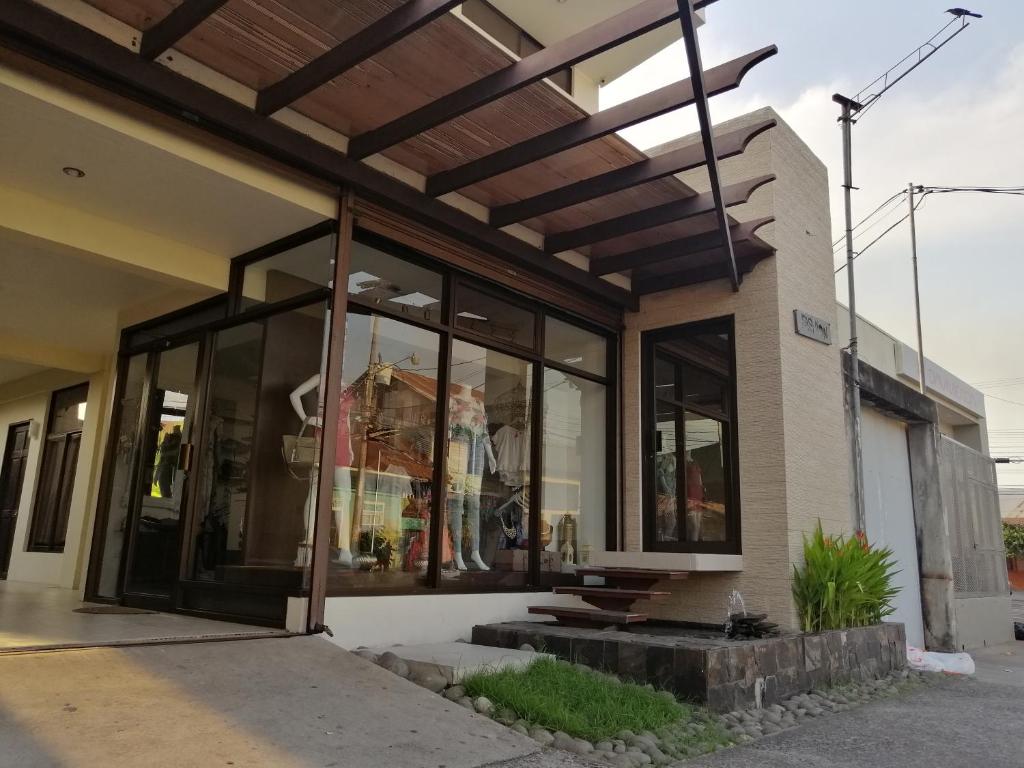 une façade de magasin avec des fenêtres en verre et un toit en bois dans l'établissement Cabinas Gosen, à Puntarenas