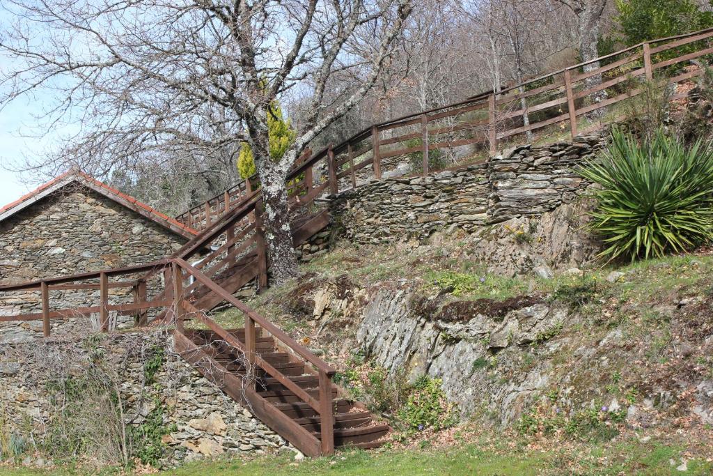 una escalera de madera en una colina con una valla en As Casas das Minas, en Zobra